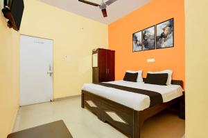a bedroom with a bed with an orange wall at Hotel O Royal Inn Hotel in Hāpur