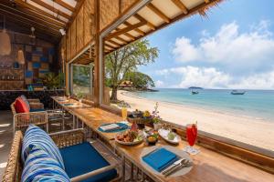 a restaurant with a table and chairs on the beach at OUTRIGGER Phi Phi Island Resort in Phi Phi Islands
