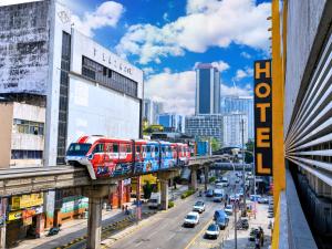 a train on a bridge over a city street at Seeds Hotel Chow Kit in Kuala Lumpur