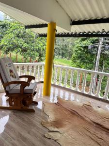 a rocking chair sitting on a porch next to a yellow pole at San Gerónimo Casa Hostal in Mocoa +13 photos