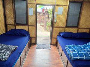 two beds in a room with a door open at New Hut Bungalow in Lamai