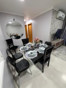 a dining room with a table and chairs and a mirror at Garden aconchegante in Manaus