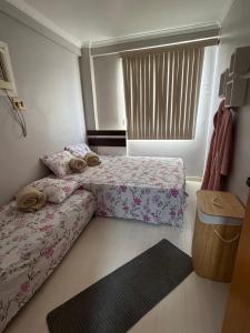 a small bedroom with two beds and a window at Garden aconchegante in Manaus +4 photos