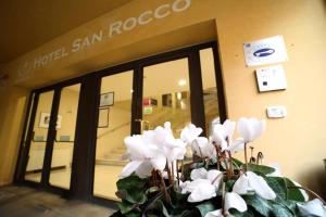 a vase of white flowers in front of a store at Hotel San Rocco in Muggia