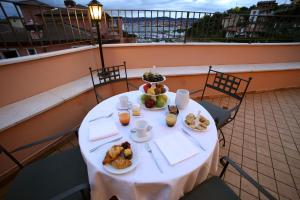 a table on a balcony with food on it at Hotel San Rocco in Muggia