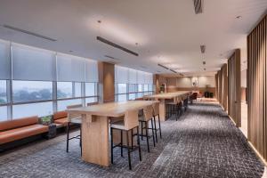 a row of tables and chairs in a room with windows at Citadines Antasari Jakarta in Jakarta
