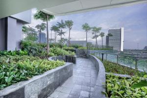 a walkway in the middle of a building with plants at Citadines Antasari Jakarta in Jakarta