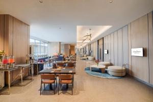 a long hallway with tables and chairs in a building at Citadines Antasari Jakarta in Jakarta