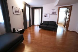 a living room with a couch and a wooden floor at Hotel San Rocco in Muggia