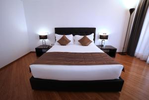a bedroom with a large bed with two night stands at Hotel San Rocco in Muggia