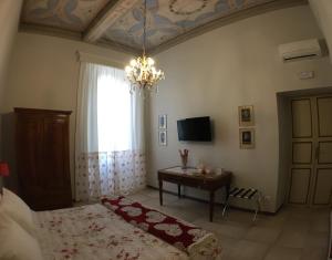 a bedroom with a bed and a table and a chandelier at B&B Theodora in Frascati