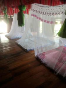 a row of white curtains on a wooden floor at Homestay mây phía đồi in Lũng Tiềm +42 photos