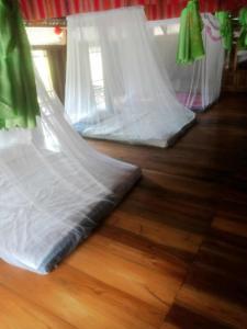 a couple of beds sitting on top of a wooden floor at Homestay mây phía đồi in Lũng Tiềm