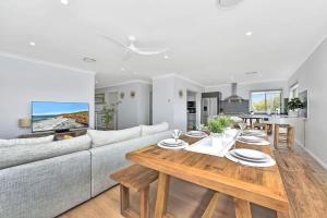 a living room with a couch and a table at Finns at Caves Beach Resort in Caves Beach