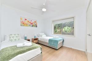a bedroom with two beds and a window at Finns at Caves Beach Resort in Caves Beach +23 photos