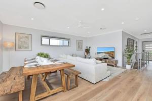 a living room with a table and a couch at Finns at Caves Beach Resort in Caves Beach