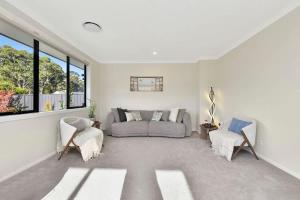 a living room with a couch and two chairs at Mount View Escape at Millfield in Millfield