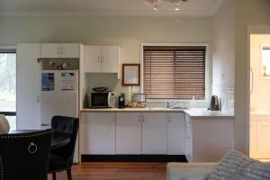 a kitchen with white cabinets and a counter top at Gartelmann Studio at Gartelmanns Wines in Rothbury +31 photos