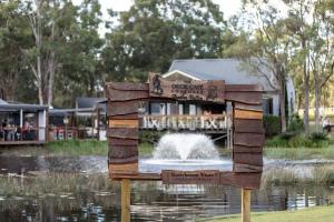 a sign in front of a pond with a fountain at Gartelmann Studio at Gartelmanns Wines in Rothbury