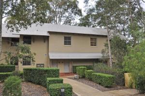 a yellow house with hedges in front of it at Villa 1br Merlot Villa located within Cypress Lakes Resort in Pokolbin