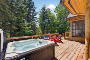 a jacuzzi tub sitting on a wooden deck at Fiddler Lake Resort - Deer 30 in Mille-Isles