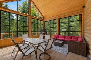 a screened in porch with a red couch and a table at Fiddler Lake Resort - Deer 30 in Mille-Isles