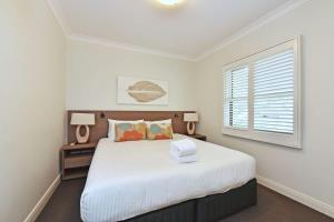 a bedroom with a large white bed with a window at Villa 2br Pinot Nois Villa in Pokolbin