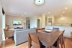 a kitchen and living room with a table and a couch at Villa 2br Pinot Nois Villa in Pokolbin