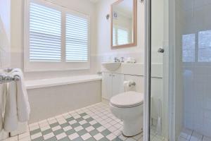 a white bathroom with a toilet and a sink at Villa 2br Pinot Nois Villa in Pokolbin +15 photos