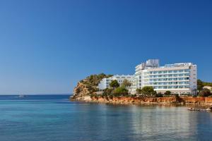 a large white building on the shore of the water at Meliá Ibiza - Adults Only in Santa Eularia des Riu