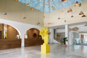 a lobby with a yellow sculpture in the middle at Meliá Ibiza - Adults Only in Santa Eularia des Riu