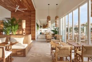 a restaurant with tables and chairs and windows at Meliá Ibiza - Adults Only in Santa Eularia des Riu