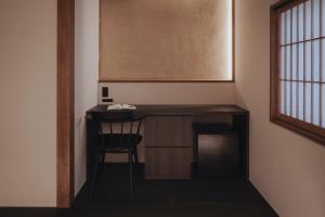a desk in a room with a chair and a window at 纏matoi in Maizuru