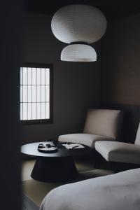 a room with a couch and a table and two lights at 纏matoi in Maizuru