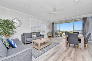 a living room with a couch and a table at Ocean Mist at Caves Beach Villas in Caves Beach