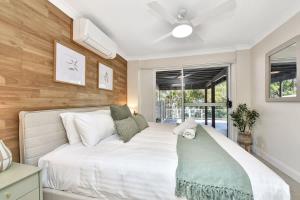 a bedroom with a large white bed and a window at Upper Deck On Dobell in Wangi Wangi