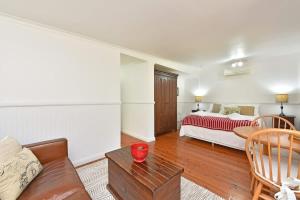 a living room with a bed and a couch at Olive Grove 1 Studio in Pokolbin