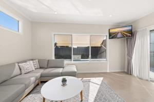 a living room with a couch and a table at Sea Sand and Serenity at Stockton - Stunning Sophistication in Stockton +28 photos