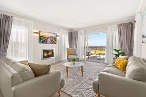 a living room with two couches and a fireplace at Sea Sand and Serenity at Stockton - Stunning Sophistication in Stockton