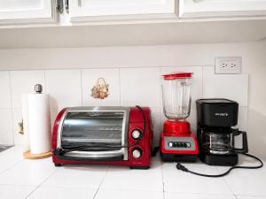 a red toaster and a blender on a kitchen counter at Gosen Stays in Antiguo Cuscatlán
