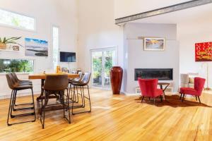 a living room with a table and chairs and a fireplace at The Lake Palace in Murrays Beach
