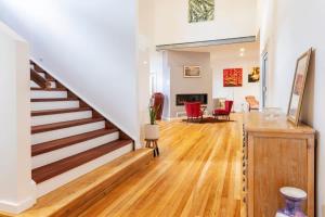 a living room with a staircase and red chairs at The Lake Palace in Murrays Beach