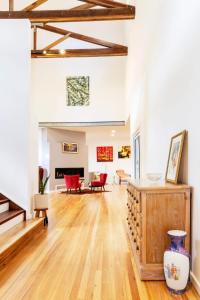 a living room with wooden floors and red chairs at The Lake Palace in Murrays Beach