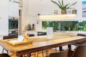 a kitchen with a wooden table with chairs around it at The Lake Palace in Murrays Beach