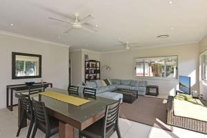 a living room with a table and a couch at Wangi Lakehouse in Wangi Wangi