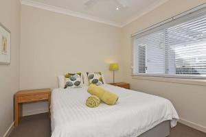 a white bedroom with a large bed with a window at Wangi Lakehouse in Wangi Wangi +18 photos