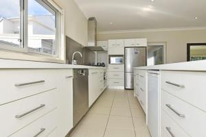 a kitchen with white cabinets and a refrigerator at Wangi Lakehouse in Wangi Wangi