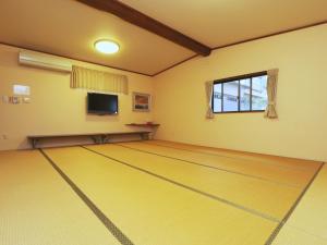 a room with a dance floor with a television at Minshuku Meiwaso in Takaoka
