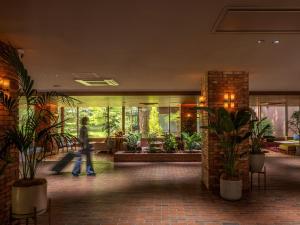 a person walking through a lobby with plants at UNWIND HOTEL & BAR Okunikko in Nikko
