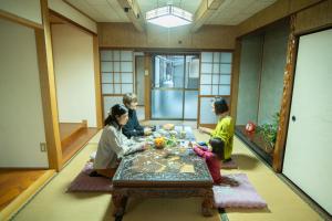 a group of people sitting around a table in a room at 宇佐神宮近く- 神さまと仏さまと kamisama to hotokesama to in Nagasu